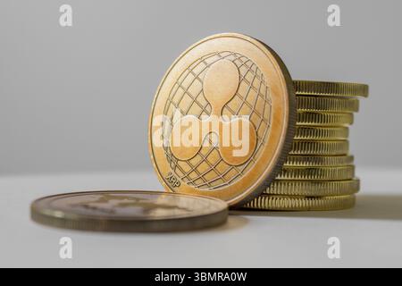 Concetto di investimento in ripple (XRP) e criptovaluta: Monete in metallo fisico Ripple con sfondo bianco Foto Stock