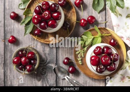 Panna cotta con gelatina dolce di ciliegia su un tavolo rustico. Dessert italiano, cucina casalinga. Vista dall'alto Foto Stock