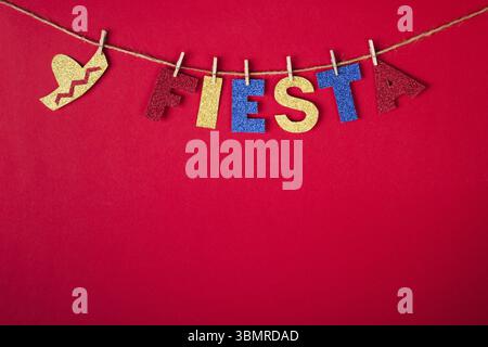 Fiesta parola e sombrero su spille in carta lucida su sfondo rosso. Cinco de mayo concetto Foto Stock