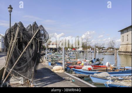 Le reti da pesca in banchina, in background le barche da pesca Foto Stock