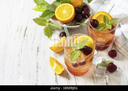 Bevanda rinfrescante ghiacciata, limonata di cola alla ciliegia all'arancia o cocktail di mojito in bicchiere su un tavolo di legno. Drink estivo fresco. Copia spazio Foto Stock