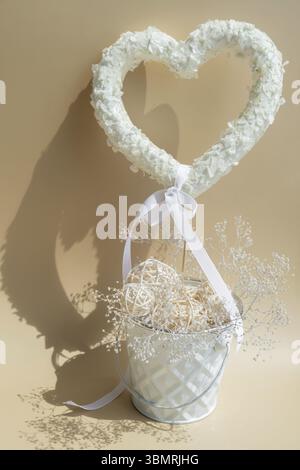 Decorazioni a forma di cuore con fiori di lilla bianchi per un regalo in uno sfondo pastello. Simbolo d'amore composizione floreale. Idea di primavera San Valentino, noi Foto Stock