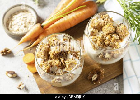 Cottura vegana senza glutine. Torta di carote con noci e cannella in un bicchiere su sfondo chiaro. Dessert sano Foto Stock