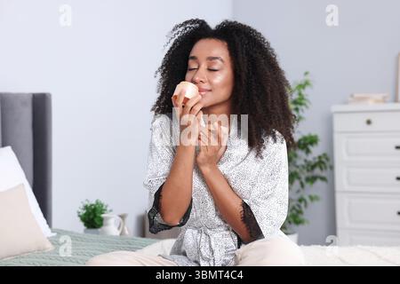 Bella donna brasiliana con barattolo di crema al collagene al chiuso Foto Stock