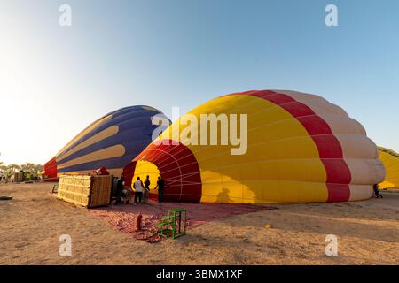 Un paio di mongolfiere gonfiate all'alba per un tour aereo della Valle dei Re, Luxor, Egitto Foto Stock