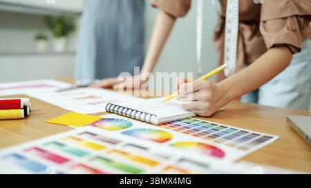 Giovane atelier o sartoriale su un tavolo da studio, stilista di moda Foto Stock