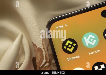 Dhaka, Bangladesh - 7 maggio 2025: L'icona dell'app Binance e KuCoin viene visualizzata sullo smartphone Foto Stock