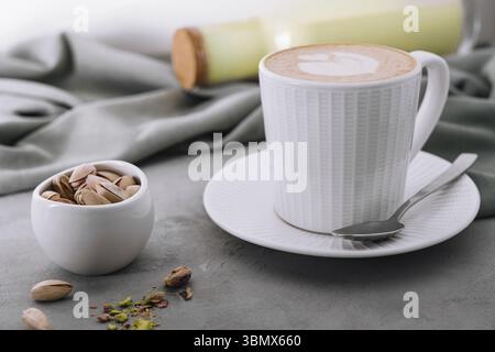 Natura morta alimentare, tazza di caramello art e pistacchi Foto Stock