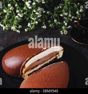 Cibo natura morta, Mousse Cake Snickers su piatto nero Foto Stock