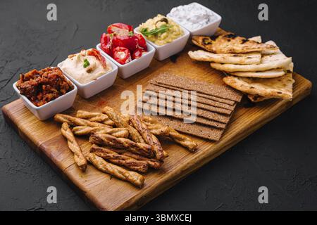 Natura morta del cibo, gustosi salse assortite su vassoio di legno Foto Stock