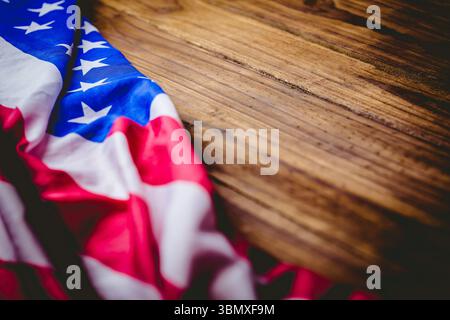 La bandiera americana piegata poggia su un tavolo in legno dal design piatto e mostra stelle e strisce Foto Stock