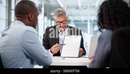 Consulente finanziario assiste Young Couple negli investimenti immobiliari Foto Stock
