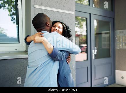 Agente immobiliare stringe la mano a diverse coppie di amici di Estate. Foto Stock