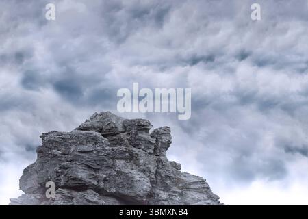 l'illustrazione con design piatto mostra la formazione di rocce grigie frastagliate a strati sotto la copertura delle nuvole dense Foto Stock