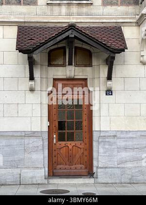Una porta in legno splendidamente lavorata è il punto focale di questo edificio classico esterno. Foto Stock