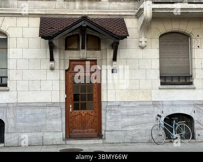 Una porta in legno splendidamente lavorata è il punto focale di questo edificio classico esterno. Foto Stock