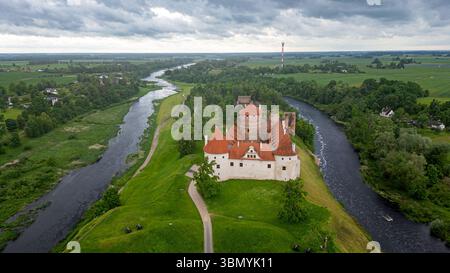 Vista aerea di un castello di Bauska circondato da alberi e un fiume Foto Stock