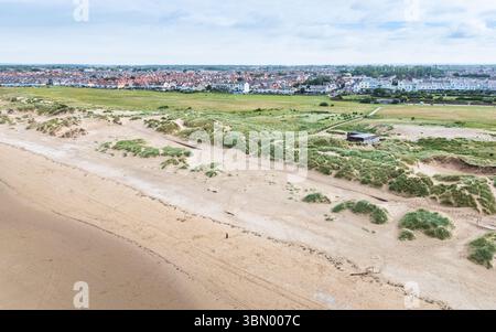 Un'immagine aerea che guarda verso il basso su una statua solitaria di Iron Man sostenuta dalle dune di sabbia sulla spiaggia di Crosby vicino a Liverpool. Foto Stock