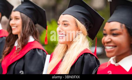 Bella signora bionda in piedi tra il gruppo internazionale di studenti Foto Stock