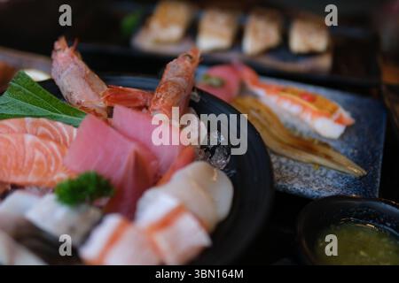 Piatto di sushi gourmet di pesce con un assortimento di nigiri e panini freschi, splendidamente presentati su un piatto bianco. Perfetto per mettere in risalto la cucina giapponese, ottimi ristoranti Foto Stock