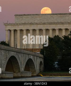 La Luna piena, conosciuta anche come la Luna del lupo, sorge sopra il Lincoln Memorial e il Memorial Bridge, come si vede dall'Arlington Memorial Bridge Foto Stock