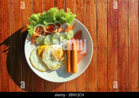 si tratta di uova fritte su un piatto bianco sotto la luce del sole. Foto Stock