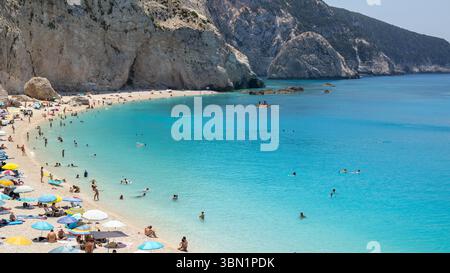 spiaggia affollata, acque turchesi e scogliere rocciose Foto Stock