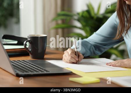 Primo piano di un impiegato che scrive un documento in ufficio Foto Stock