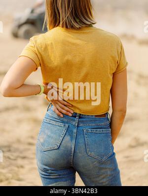 Donna che indossa jeans e t-shirt per assistere alle gare di fuoristrada Foto Stock