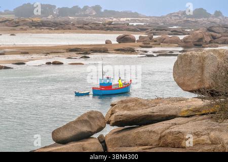 Francia. Brittany. Cotes d'Armor. Ploumanach (o Ploumanaca'h) peschereccio tra i blocchi di granito rosa caratteristici del luogo Foto Stock
