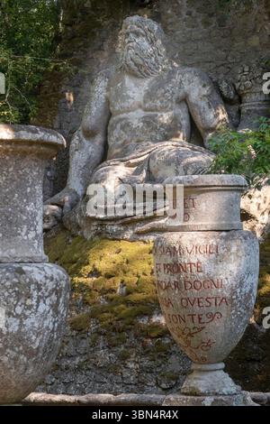 Italia. Lazio. I giardini di Bomarzo. Conosciuto anche come Sacro Bosco o Monster Park. xvi secolo. Statua di Nettuno che protegge una sorgente d'acqua viva Foto Stock