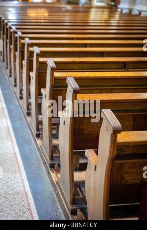 Una fila di pali vuote in una chiesa Foto Stock