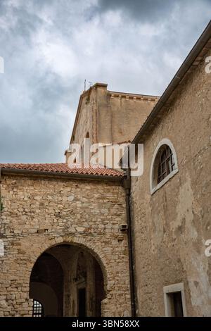 basilica euforica facciata storica della chiesa in pietra con tradizionale architettura mediterranea, porta ad arco, campanile e tegole in terracotta ag Foto Stock