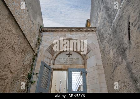 Ingresso alla basilica euforica medievale in pietra con iscrizione latina scolpita e croce cristiana a Parenzo, Croazia. Architettura religiosa storica Foto Stock