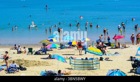 Lyme Regis, Dorset, Regno Unito. 30 giugno 2025. Meteo nel Regno Unito. I bagnanti affollarono la spiaggia affollata presso la località balneare di Lyme Regis per crogiolarsi al caldo sole nel giorno più caldo dell'anno finora. Le temperature sono destinate a salire bene a metà degli anni '30, mentre l'ondata di calore di giugno persiste. Crediti: Celia McMahon/Alamy Live News Foto Stock