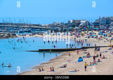 Lyme Regis, Dorset, Regno Unito. 30 giugno 2025. Meteo nel Regno Unito. I bagnanti affollarono la spiaggia affollata presso la località balneare di Lyme Regis per crogiolarsi al caldo sole nel giorno più caldo dell'anno finora. Le temperature sono destinate a salire bene a metà degli anni '30, mentre l'ondata di calore di giugno persiste. Crediti: Celia McMahon/Alamy Live News Foto Stock