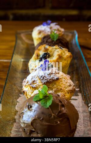 Una varietà di diversi muffin dolci su un piatto di vetro allungato Foto Stock