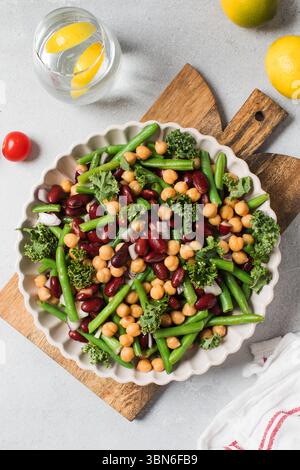 Insalata di verdure fresche con fagioli verdi, ceci, cavoli e fagioli rossi su tavola di legno Foto Stock