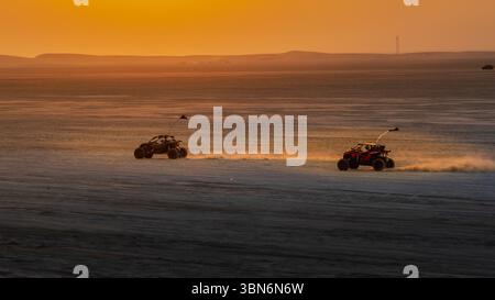Doha, Qatar-22 gennaio 2025: Un'emozionante esperienza di esplorazione delle dune nel deserto Sealine, con veicoli fuoristrada che sfrecciano attraverso le dune di sabbia dorata Foto Stock