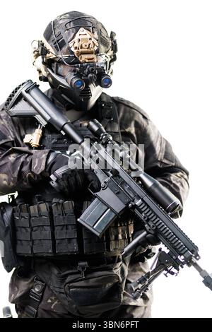 Un operatore specializzato in equipaggiamento tattico avanzato ha un'arma da fuoco, dimostrando prontezza e professionalità. Dotato di attrezzature moderne, il soldato e Foto Stock