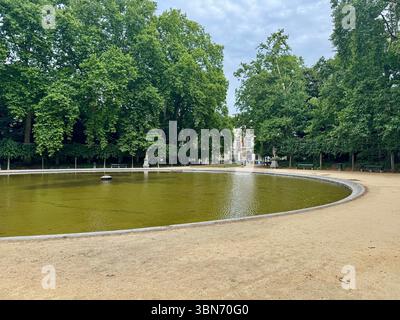 Laghetto ornamentale circolare circondato da alberi in un parco pubblico di Bruxelles, Belgio. Foto Stock