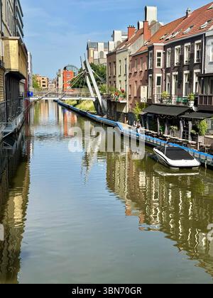 Vista sul canale con moderna passerella e storiche case lungo il fiume a Gand (Gent), Belgio. Foto Stock