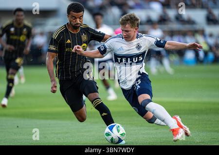 Il difensore dei Vancouver Whitecaps Tate Johnson (28) viene sfidato dal centrocampista del LAFC Timothy Tillman (11) durante un MLS match, domenica 29 giugno 2025, al BMO Stadium di Los Angeles, CALIFORNIA. I Whitecaps sconfissero il LAFC 1-0. (Jon Endow/immagine dello sport) Foto Stock