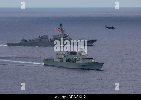 240618-N-HT008-1821 SOUTH CHINA SEA (18 giugno 2024) il cacciatorpediniere missilistico guidato classe Arleigh Burke USS Ralph Johnson (DDG 114), a sinistra, conduce bilat Foto Stock