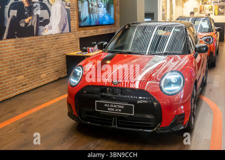 Mini JCW rossa con capote con la targhetta "All Electric Mini JCW" in uno showroom Foto Stock