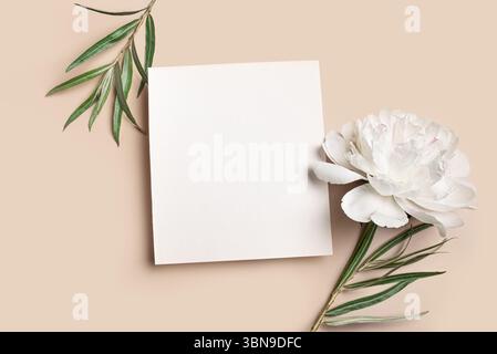 Mockup per biglietti d'auguri o biglietti d'invito, bianco vuoto 1x1 con decorazioni floreali su sfondo beige neutro, spazio di copia per il testo. Fantasia elegante Foto Stock