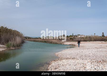 Pesca al suolo nel fiume Cervera o Río Seco che sfocia in Playa de la Mar Xica, Benicarló, Castelló de la Plana, Comunità Valenciana, Spagna Foto Stock