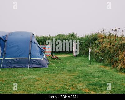 Una tenda frangivento e una linea di lavaggio in una nuvolosa giornata umida nel Regno Unito Foto Stock