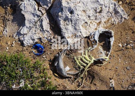 Le attrazioni turistiche di Cipro, Una scarpa scartata adagiata su una superficie sabbiosa. La scarpa è principalmente marrone con una suola bianca e ha una tomaia di colore chiaro, possibilmente marrone o beige. È adornato con lacci gialle e sembra essere fatto di una rete o di una rete. La scarpa è posizionata vicino a una grande roccia di colore chiaro, parzialmente incastonata nella sabbia. Vicino alla scarpa è visibile anche un piccolo oggetto blu, probabilmente un pezzo di plastica o un piccolo contenitore. La sabbia è di colore marrone chiaro e alcuni piccoli frammenti di detriti sono sparsi intorno alla scarpa e alla roccia. L'occhio di un artista e la sua immaginazione Foto Stock