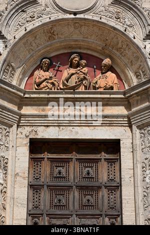 028 lunetta sopra il portale della Chiesa di Sant'Agostino con San Giovanni Battista-Madonna con bambino-Sant'Agostino. Montepulciano-Toscana-Italia. Foto Stock